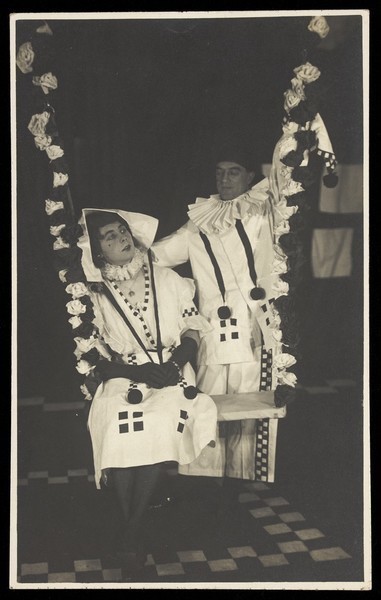 Download the full-sized image of Two British soldiers performing as clowns for "The Timbertown Follies", at a prisoner of war camp in Groningen. Photographic postcard, 191-.