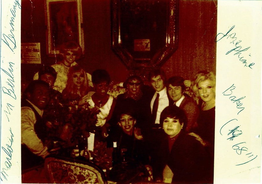 Download the full-sized image of A Photograph of Marlow Monique Dickson in a Group Posing Around a Table