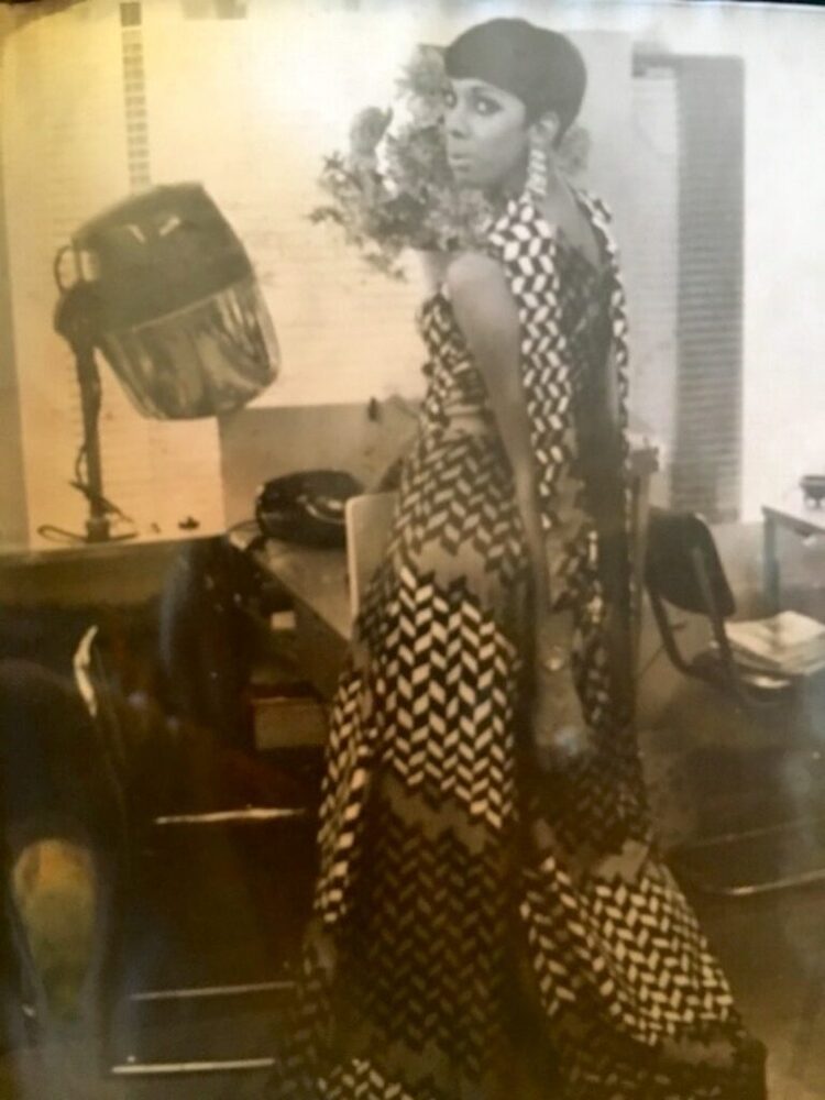 Download the full-sized image of A Photograph of Marlow Monique Dickson Looking Back at the Camera in a Black and White Dress
