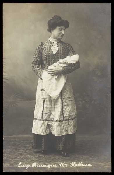 Download the full-sized image of A man in drag holding a baby. Photographic postcard by Photo Jos. Dumont.