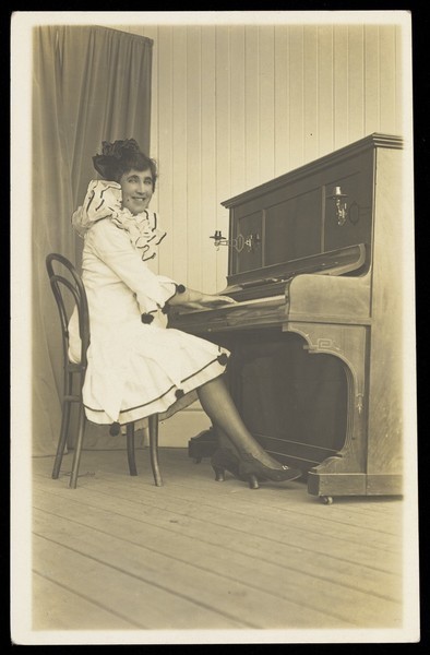 Download the full-sized image of A man in drag playing the piano. Photographic postcard by Legg (?) & Co., 192-.