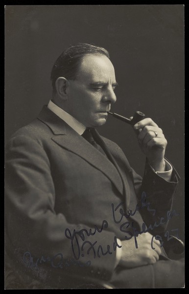 Download the full-sized image of Fred Spencer in male dress smoking a pipe. Photographic postcard, 192-.
