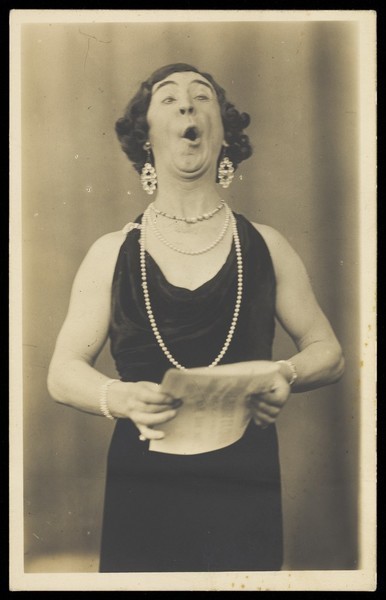 Download the full-sized image of A man in drag singing. Photographic postcard, 193-.