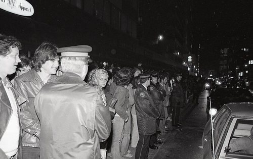 Download the full-sized image of People Line the Street Behind Police Officers