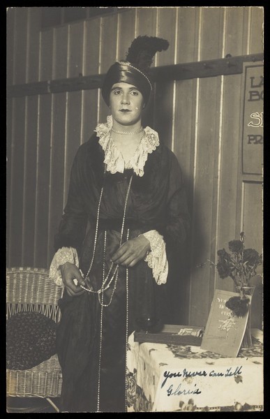 Download the full-sized image of A British prisoner-of-war at Krefeld camp, in drag, poses in character. Photographic postcard, 191-.