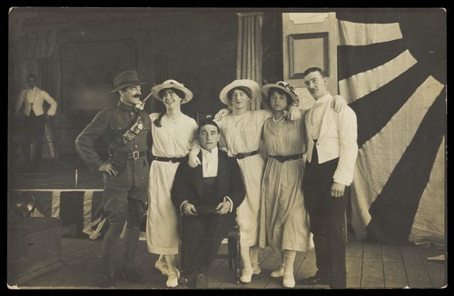 Download the full-sized image of Servicemen performing a play, in front of the stage. Photographic postcard. 191-.