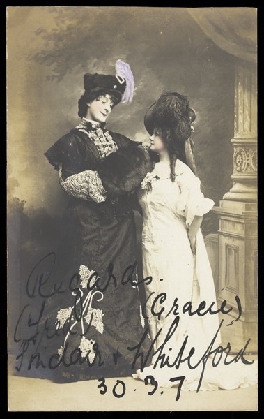 Download the full-sized image of Fred Sinclair in drag and Gracie Whiteford pose in character. Photographic postcard, 1907.